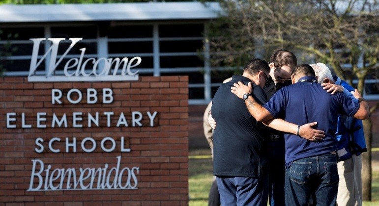 Homens se abraçam após um tiroteio em massa na Robb Elementary School, no Texas