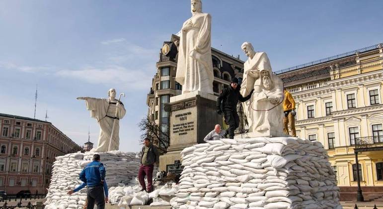 Voluntários ucranianos cobrem esculturas com sacos de areia para evitar danos