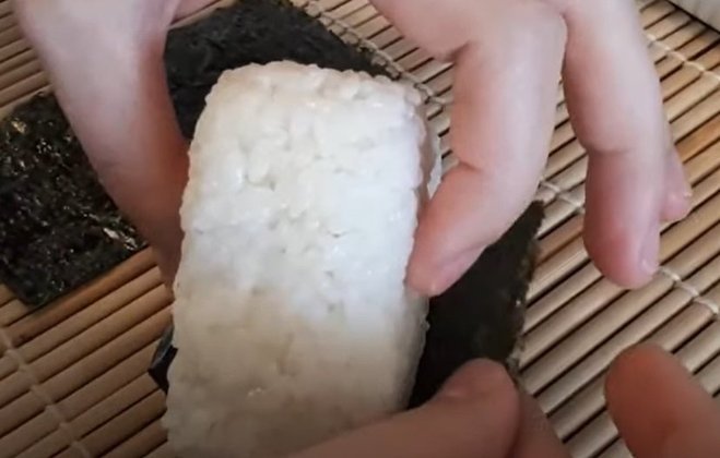Esse tradicional bolinho de arroz é um dos mais conhecidos em restaurantes típicos e geralmente ele tem uma forma triangular característica. 