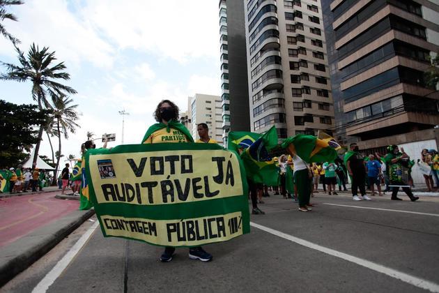 Os presentes vestiam principalmente roupas de verde e amarelo e carregavam cartazes em apoio a Bolsonaro 