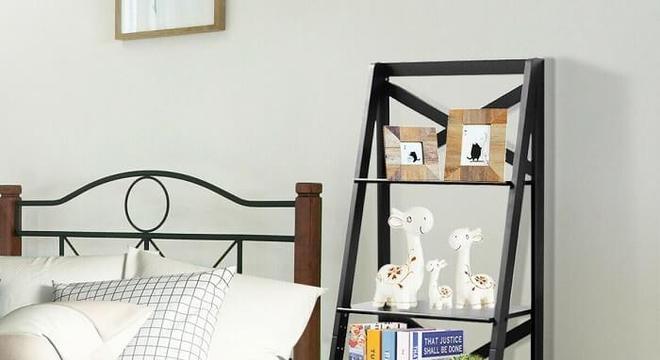 Estante escada preta posicionada ao lado da cama de casal facilita o acesso de diversos itens