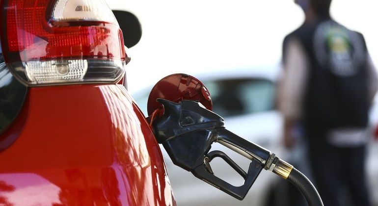 Carro abastecendo em posto de gasolina

