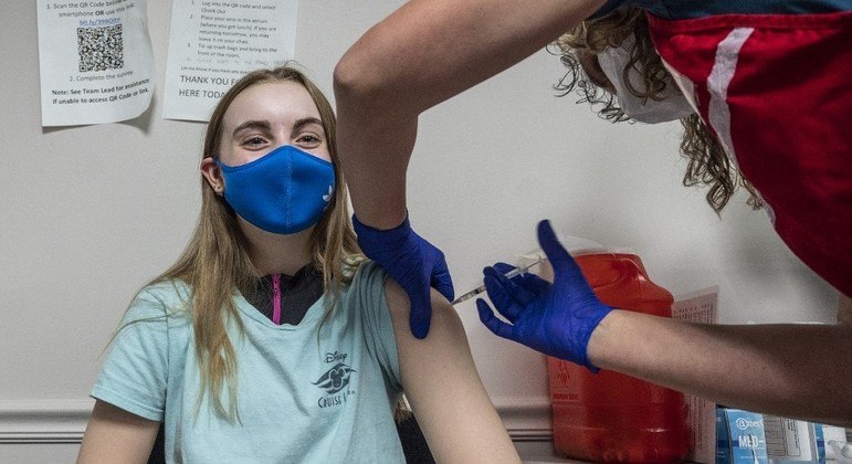 Adolescente de 13 anos recebe vacina contra covid em centro de imunização na Virgínia