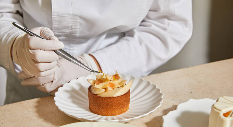 Chef do restaurante Jungsik, em Nova York, mostra todo o cuidado na finalização de uma sobremesa