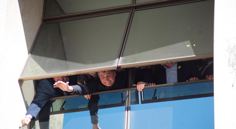Ex-presidente Jair Bolsonaro acena para apoiadores de uma janela na sede do PL em Brasília