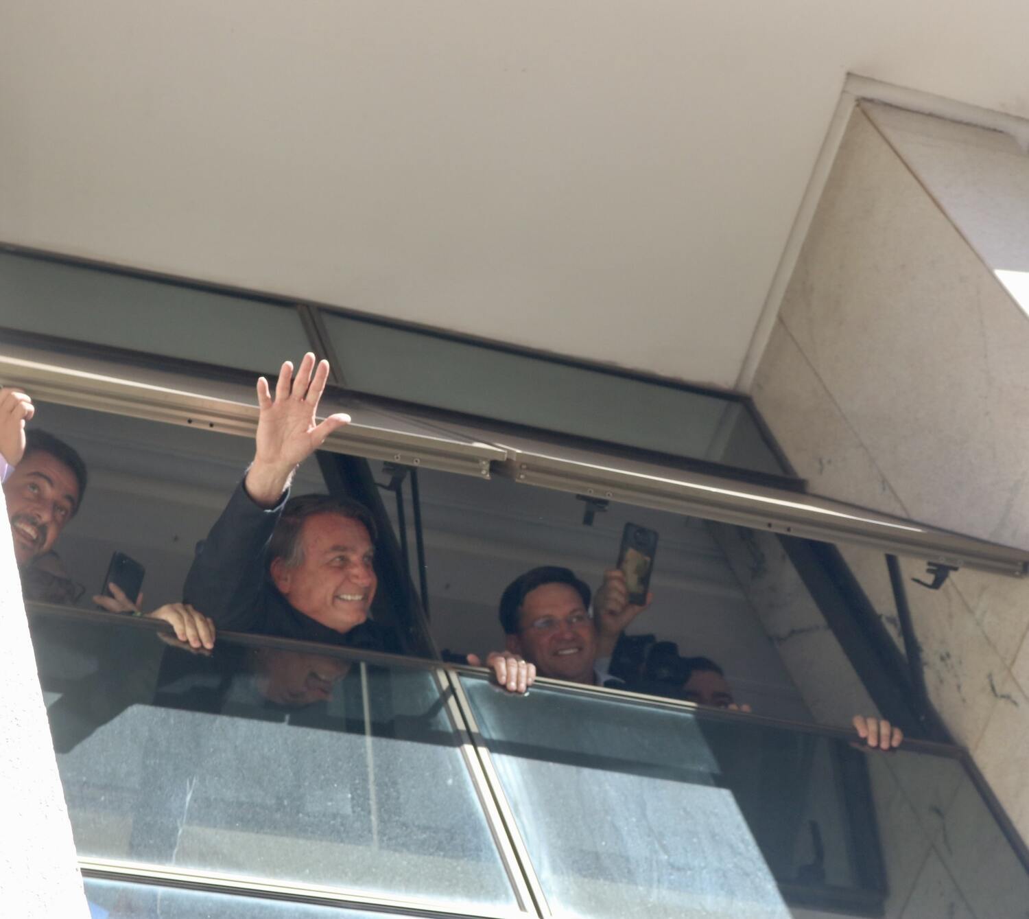 Ex-presidente Jair Bolsonaro acena de uma janela na sede do PL, no Brasil 21, em Brasília