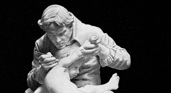 Experimento de Edward Jenner, eternizado nesta estátua vacinando o próprio filho, carrega sérias implicações éticas