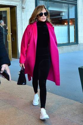 Com um blusa e calça pretas e tênis branco, Jennifer Lopez deu um up no visual ao colocar um casaco colorido por cima