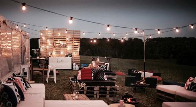 festa de casamento ao ar livre a noite decorada com pallets e varal de luz 