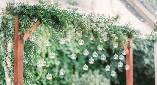 festa de casamento no campo decorada com muita folhagem e lampadas 