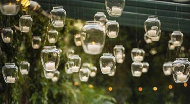 festa de casamento no campo decorada com velas suspensas e arranjo de flores coloridas 