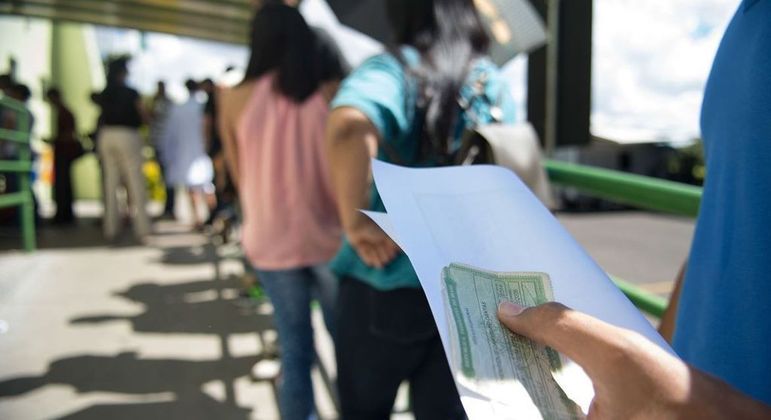 Eleitores esperam em uma fila de votação numa seção eleitoral