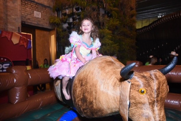 Valentina, filha de Deolane, se divertiu no touro mecânico da festa