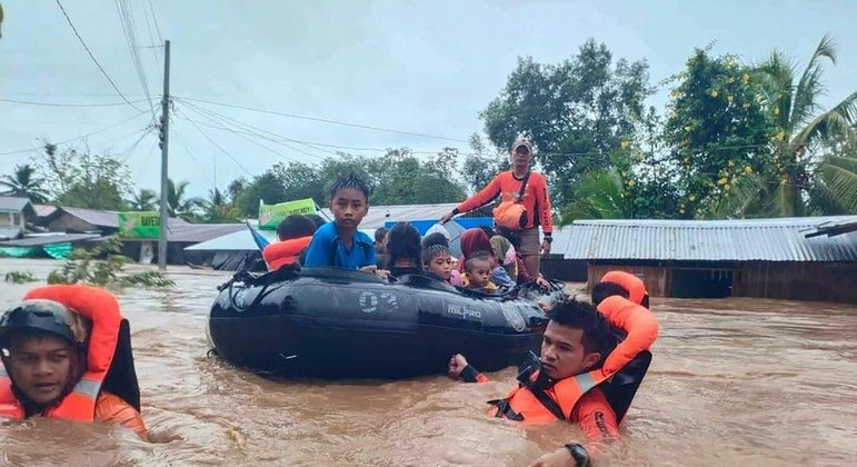 Equipes de resgate retiram crianças de uma área inundada nas Filipinas