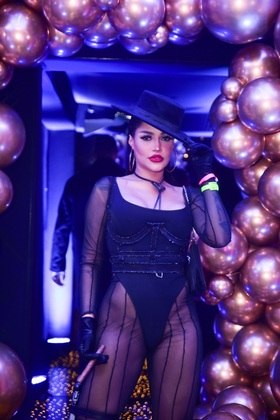 A cantora Flay apostou em um look com transparência, chapéu e até segurou um charuto para ficar mais característico
