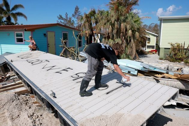 Lucas Gordon, morador da cidade de Pine Island, escreve com spray nos escombros: 'Se você saquear, vamos atirar'. Ele disse à AFP que tem medo de ser atacado por saqueadores