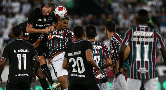 Joel Carli, do Botafogo, e David Braz, do Fluminense, disputam a bola no jogo aéreo

