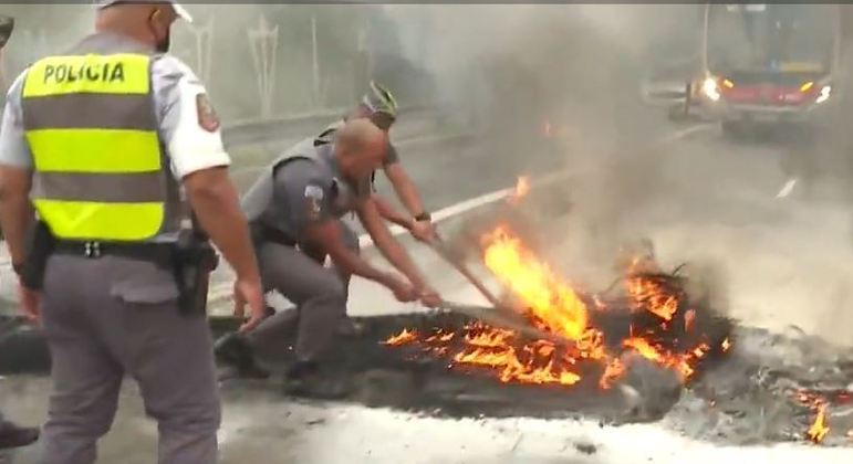 Policiais e bombeiros tentam conter fogo ateado por moradores da zona leste de SP