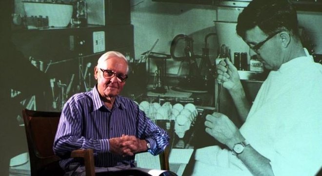 O professor Frank Fenner em frente a uma foto projetada de si mesmo, tirada na década de 1950