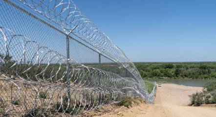 Uma cerca de arame farpado é retratada ao lado do rio Grande, no Texas, próximo à fronteira dos EUA