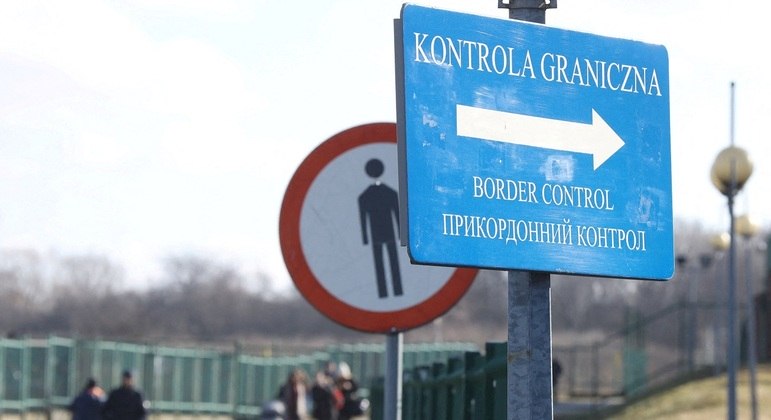 Pessoas cruzam a fronteira entre Polônia e Ucrânia
