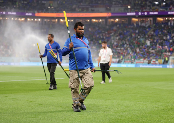 Funcionários fazem pequenos reparos no campo no intervalo