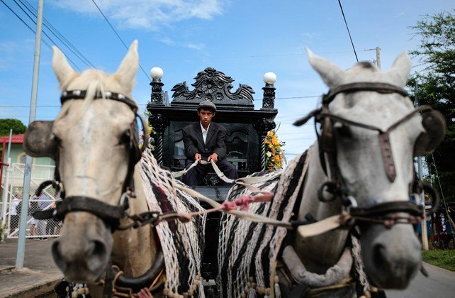 Com alguma frequência, uma carruagem elegante e preta puxada por cavalos é vista indo para o cemitério da cidade