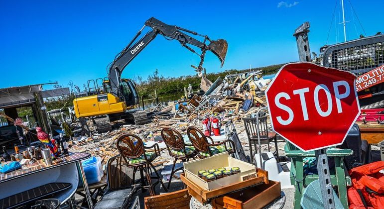 Retroescavadeira trabalha, neste sábado, na limpeza dos destroços de um bar em Fort Myers (Flórida)