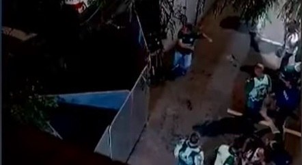 Gabriela, no alto na imagem, já teria a mão no pescoço quando palmeirense que aparece embaixo joga garrafa