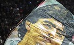 Um torcedor do Gimnasia y Esgrima agita uma bandeira com a imagem do ex-craque argentino Diego Maradona antes da partida do Torneio da Liga Profissional de Futebol Argentino 2022 no estádio Juan Carmelo Zerillo, na cidade de La Plata, Buenos Aires, em 6 de outubro