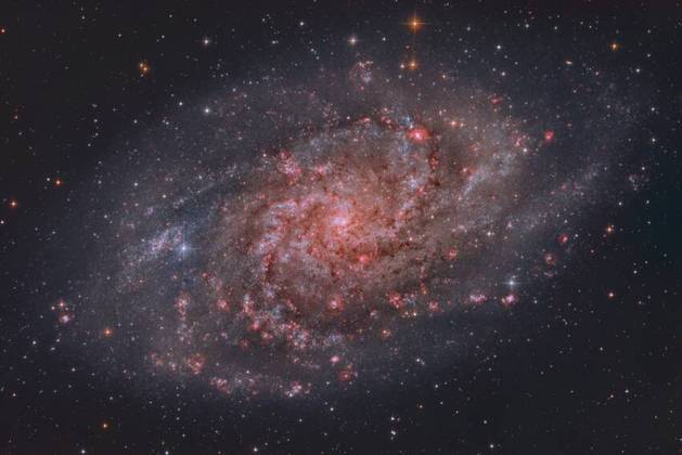 A galáxia M33, também conhecida como Galáxia do Triângulo. A imagem revela nuvens avermelhadas de hidrogênio ionizado, onde nascem estrelas massivas, que possuem vida curta, mas intensaNão saia daí! Cosméticos usados há 2.000 anos são desenterrados por arqueólogos
