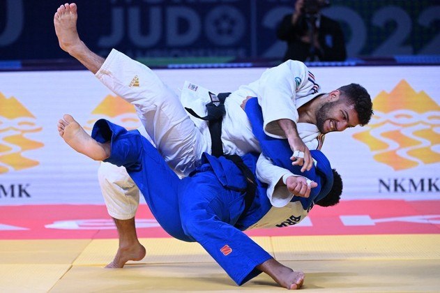 O francês Alexis Mathieu (branco) e o brasileiro Marcelo Gomes competem na eliminatória da categoria até 90 kg masculino durante o Campeonato Mundial de Judô de 2022, na Humo Arena, em Tashkent, em 10 de outubro