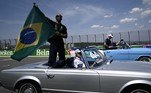 O piloto britânico da Mercedes, Lewis Hamilton, agita uma bandeira nacional brasileira durante o desfile de pilotos antes do Grande Prêmio do Brasil de Fórmula 1 no autódromo José Carlos Pace, também conhecido como Interlagos, em São Paulo, em 13 de novembro
