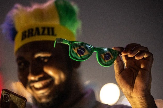 Um torcedor do Brasil sorri em Doha, ostentando os itens que usa para torcer pela seleção brasileira, em 17 de novembro