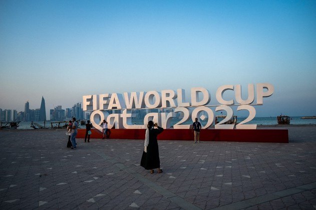 Visitantes tiram fotos com uma placa da Copa do Mundo da FIFA em Doha em 23 de outubro de 2022, antes do torneio de futebol da Copa do Mundo da FIFA Qatar 2022