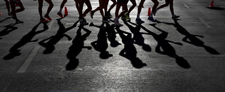 Atletas projetam suas sombras na calçada enquanto competem na caminhada de 35 km masculina e feminina no Campeonato Europeu de Atletismo em Munique, sul da Alemanha, em 16 de agosto