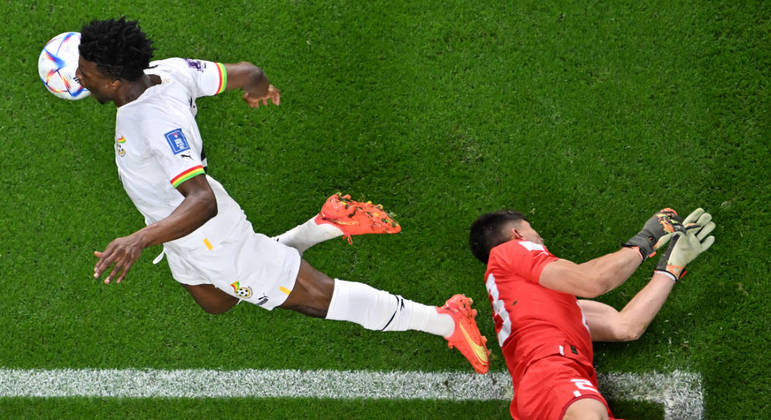 Atacante de Gana, Kudus divide o lance com o goleiro uruguaio Rochet