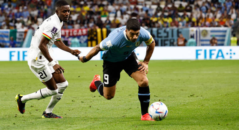 O uruguaio Suarez tenta passar pela marcação do ganense Samed