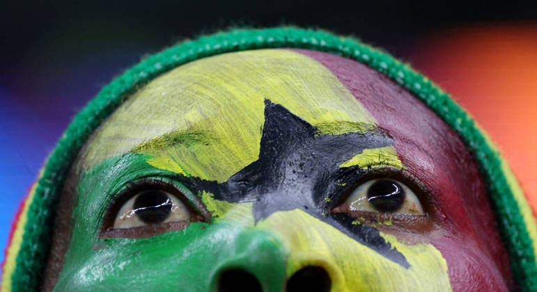Torcedor de Gana pinta o rosto para torcer por sua seleção contra o Uruguai