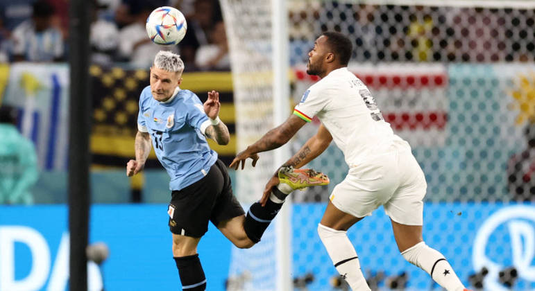 Varela afasta a bola na frente de Ayew no início do jogo entre Uruguai e Gana