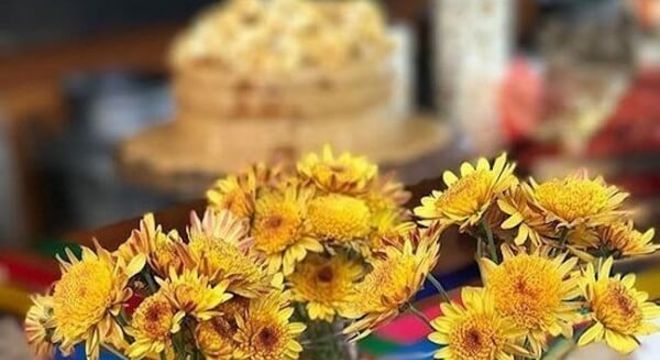 Garrafas de vidro transparente e pipoca decoram a mesa dos convidados da festa tema girassol