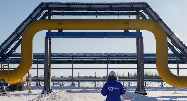 Funcionário passa por uma parte de um gasoduto da Gazprom, na Rússia