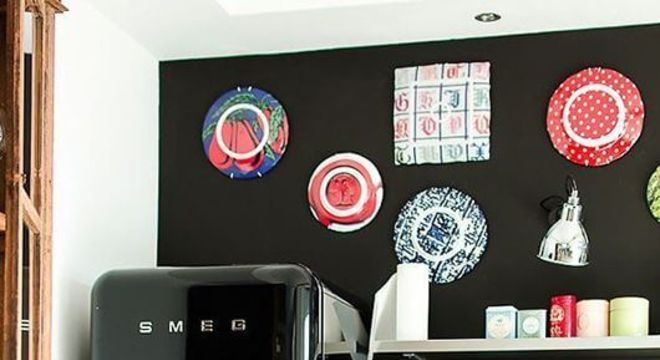 Geladeira retrô preta com armários de madeira e parede estampada