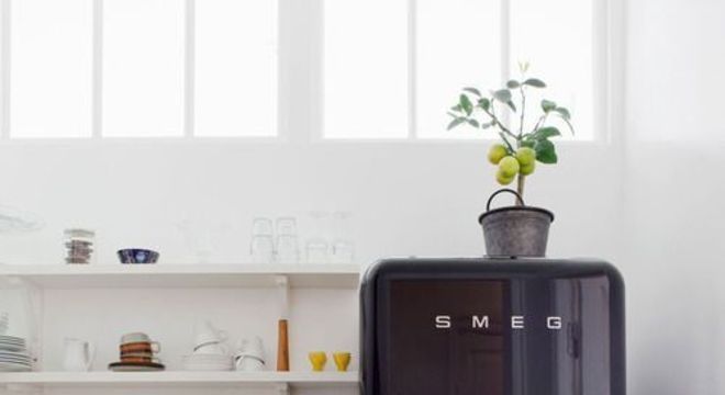 Geladeira retrô preta na cozinha pequena e branca