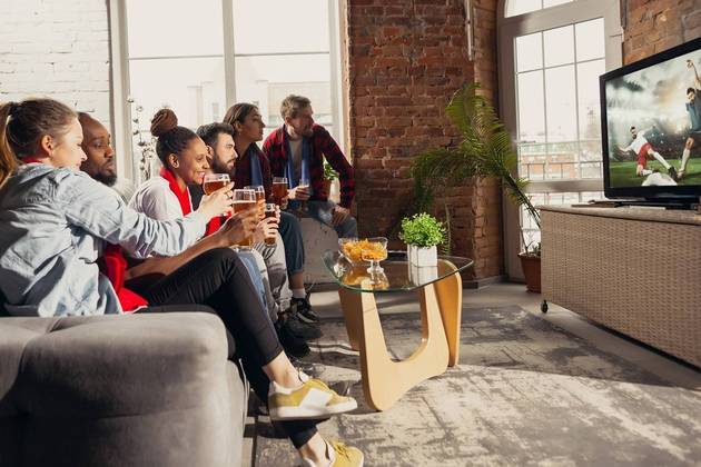 Grupo de amigos assiste jogo de futebol em SmartTV. Freepik/master1305