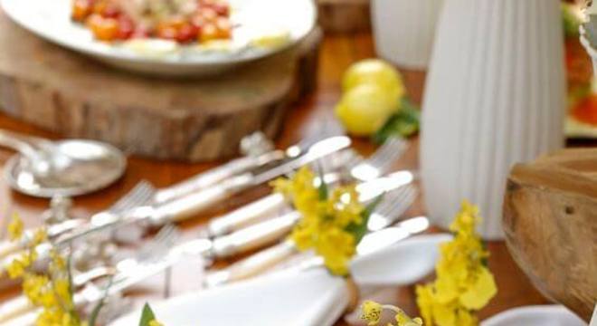 Guardanapo de tecido branco e bordado com flores amarelas no anel