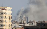 Já com o dia claro ainda é possível ver a coluna de fumaça sobre prédios em Gaza