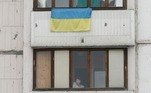 Mulher olha pela janela de apartamento, em Kiev, enquanto invasão russa da Ucrânia continua 