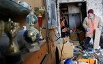 Funcionários municipais removem detritos de um apartamento, que moradores disseram ter sido danificado por bombardeios recentes, na cidade controlada pelos separatistas de Yasynuvata (Yasinovataya) na região de Donetsk, na Ucrânia