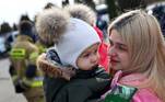 Uma mulher chora com o filho nos braços ao desembarcar de um ônibus na vila de Moszczany, perto do posto de fronteira em Korczowa, na Polônia, depois de fugir da Ucrânia por causa da invasão russa 